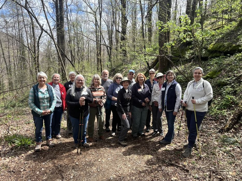 A group of hikers pose together on a trail.