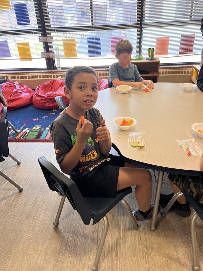 Kids eat snacks at a table.