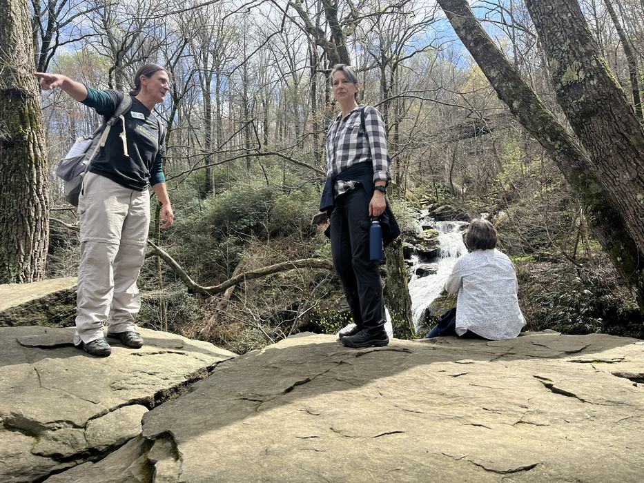 Two hikers talk while taking a break. 