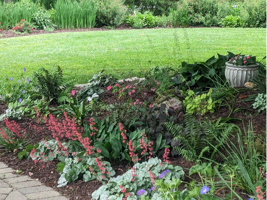 A short garden bed with a decorative pot.