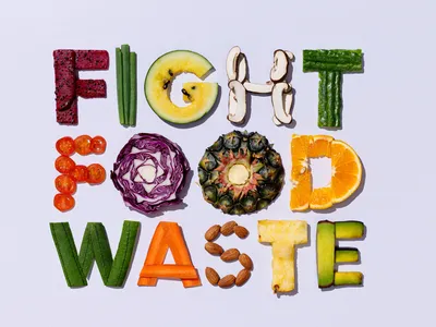 Letters made from fruits, vegetables, and nuts spelling "FIGHT FOOD WASTE"