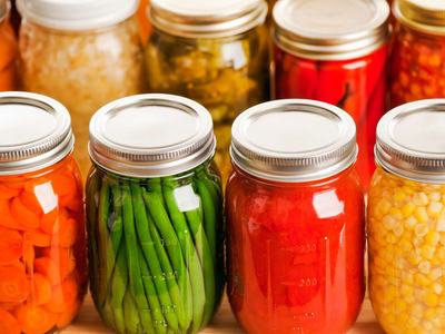 Row of canned carrots, green beans, peppers, and corn