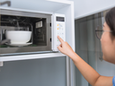 bowl in microwave with woman pushing buttons