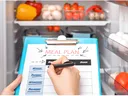Looking in refrigerator to determine what to add to a grocery list.