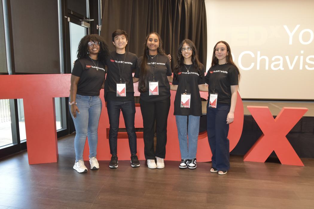 Youth stand in front of TEDx letters.