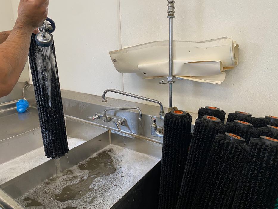 Rollers being washed in three compartment sink