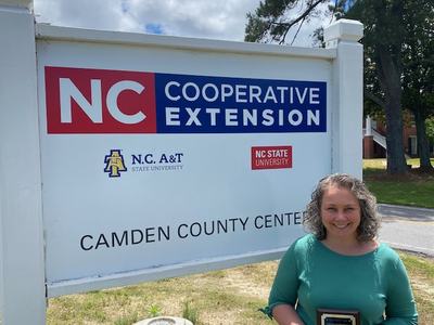 A woman poses in front of the Camden County Center sign.