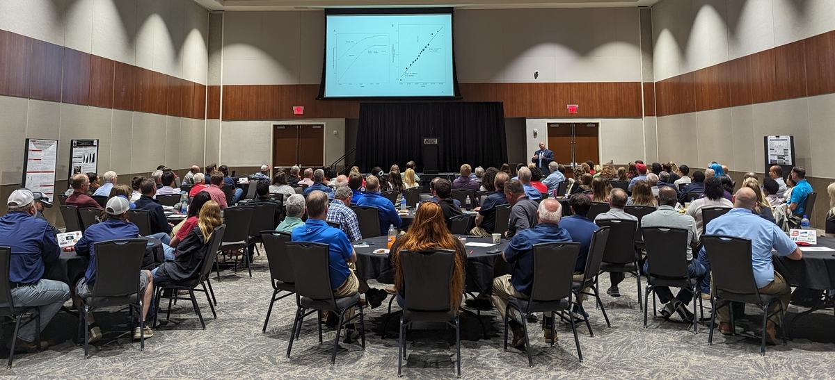 A group of people in a conference hall listening to a lecture.