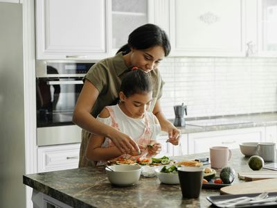 mom and daughter preparing food