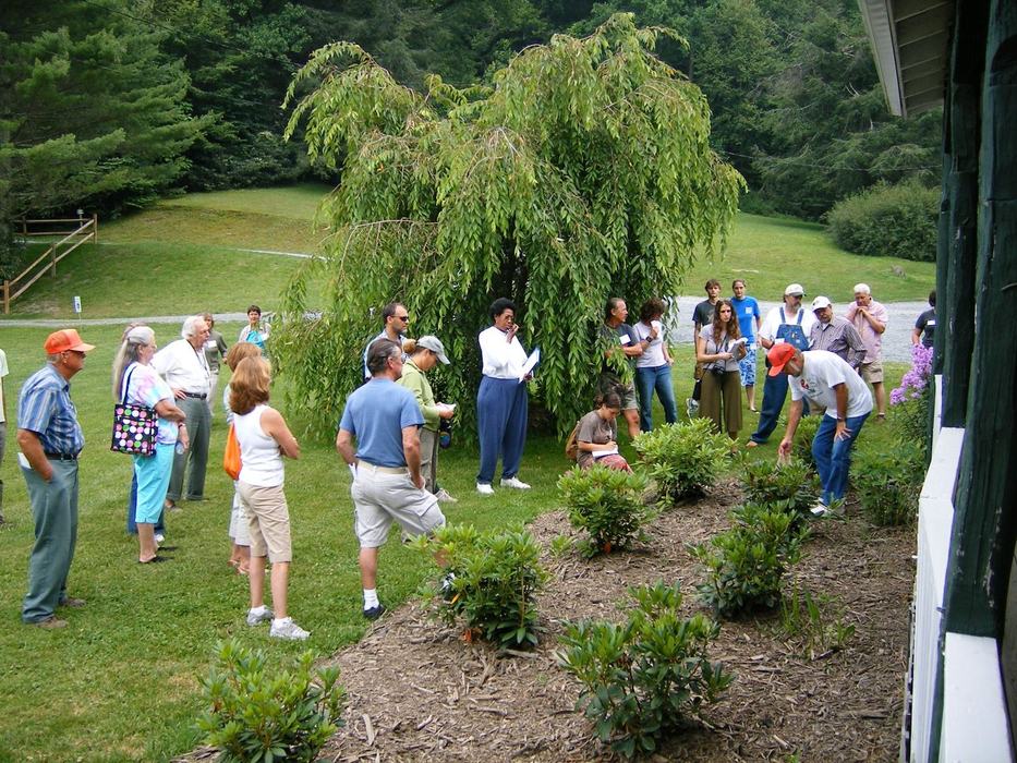 people gathered around a teacher outside learning about herbs