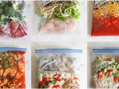 Six labeled freezer meal zip bags with raw ingredients (e.g., Beef & Broccoli, Jambalaya)