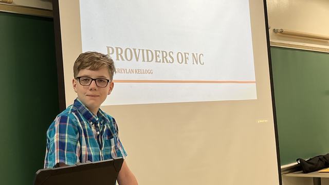 A kid stands to give a presentation.