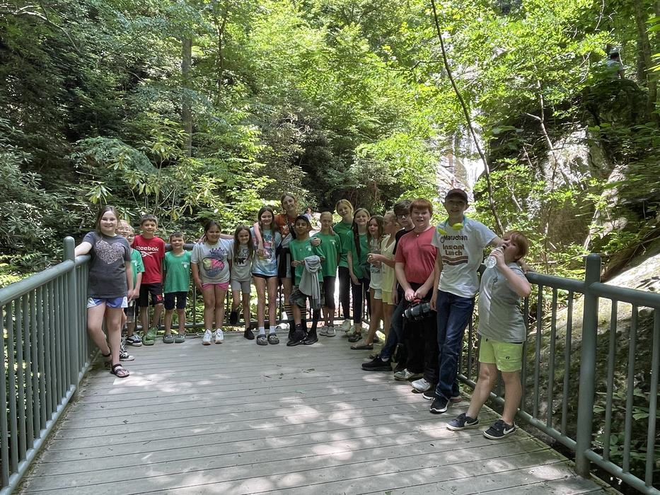A group of children pose together on a scenic overlook.