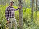 Image of Dr. Will Kohlway standing next to a poplar tree in a forest.