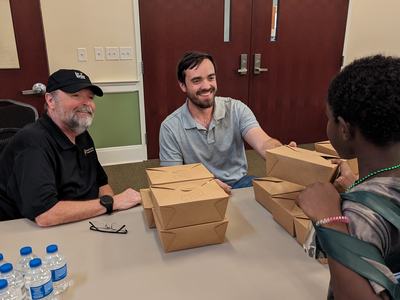 Chef John LaTour, Healthy Families-Healthy Futures and Avery Ashley, Family and Consumer Science Extension Agent pass out meals at the Care Fair