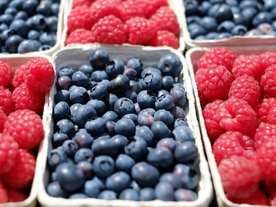 Containers of fresh blueberries and raspberries in paper trays
