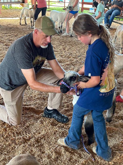 Livestock Agent teaching 4-H'er how to set up