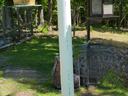 White PVC pole with T-shaped hanger holding two bird feeders in a grassy yard