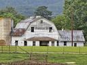 Weathered white barn with faded "TRIPLE R" sign, silo at left and grassy foreground