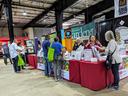 Booth for "Successful Gardener" with staff advising visitors at an indoor fair