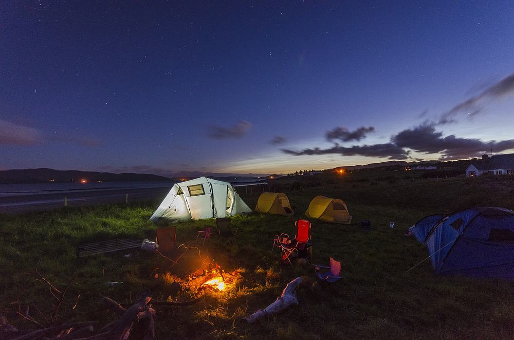 Tents at night near a fire.