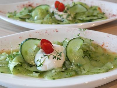 image of 2 white bowls of cucumber salads