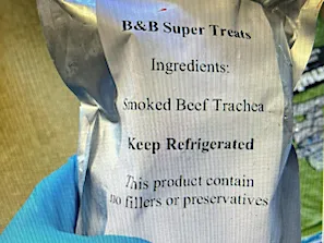 gloved hand holding foil package of B&B Super treats