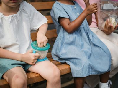 kids sitting on bench eating snacks