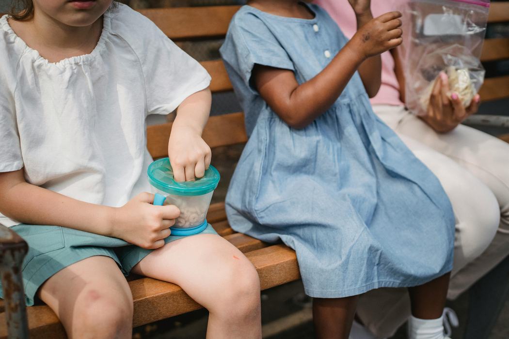 kids sitting on bench eating snacks