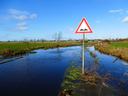 flooded ground with a warning sign