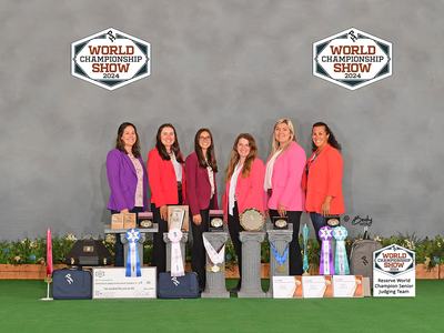 Six women behind trophies and ribbons at World Championship Show 2024.