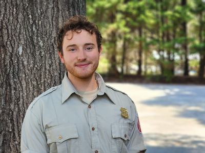 A young man in a forestry shirt.