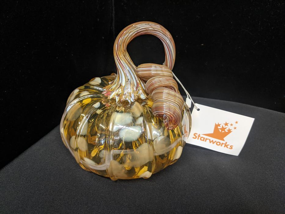 A brown and orange, handblown, glass pumpkin.