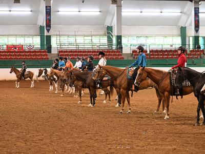 Riders in helmets lined up on horses in an indoor arena; banner reads "North Carolina"