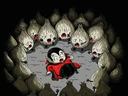 Child vampire in red cape lying on ground surrounded by a ring of crying garlic bulbs