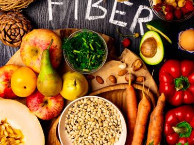 Foods rich in fiber as rye galette , wheat bran, beans , almonds, seed, pears, plum bananas, cranberry, raspberries, pistachios, red pepper kiwi walnuts melon celery carrot Wooden table as background