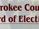 Cherokee County Board of Elections sign with faint American flag background