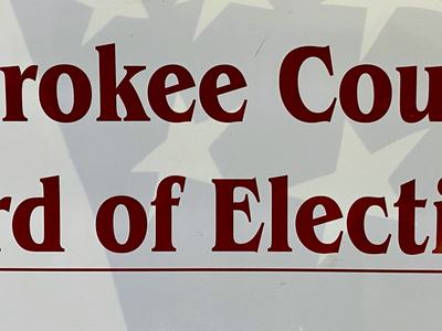 Cherokee County Board of Elections sign with faint American flag background
