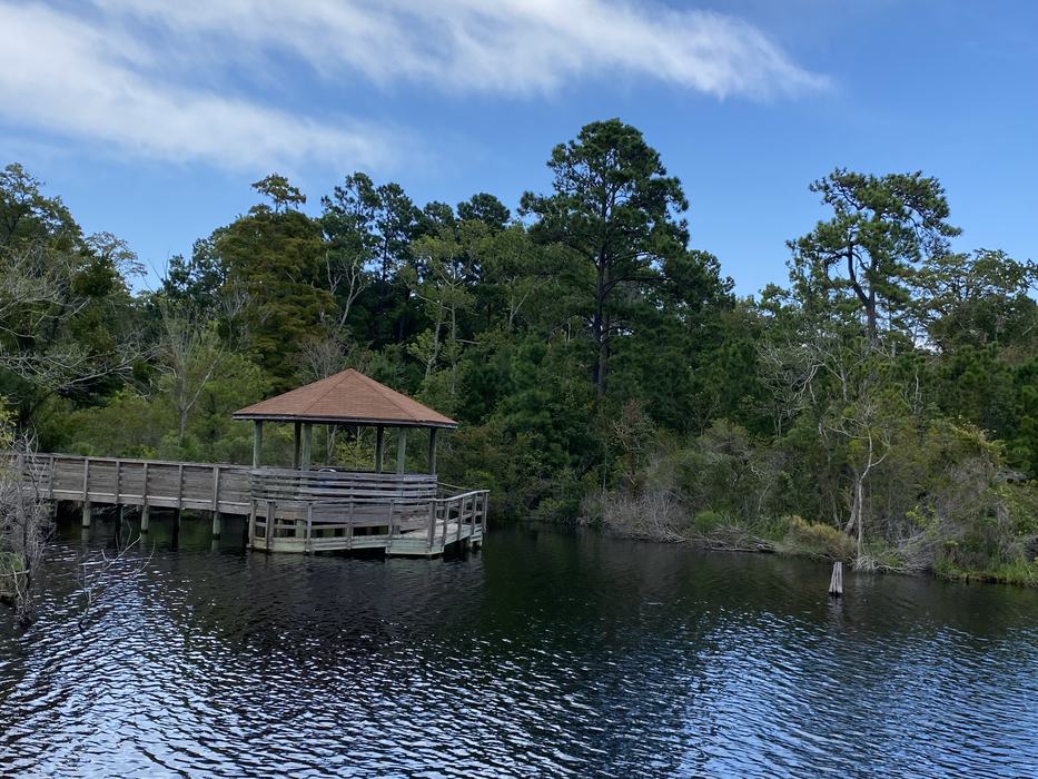 A gazebo at the end of a dock, there is a boat ramp for kayaks.