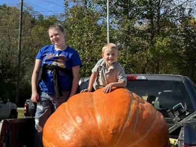 Two 4-H youth with their giant pumpkin