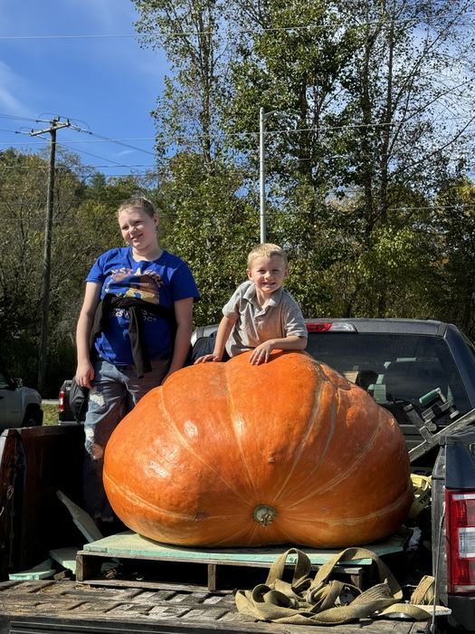 Two 4-H youth with their giant pumpkin