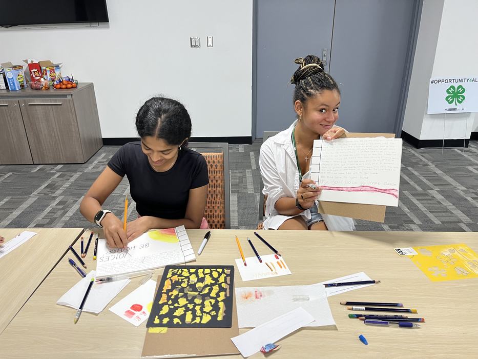 two girls drawing at a table
