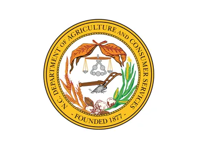 N.C. Department of Agriculture and Consumer Services seal with plow, crops, scales; "Founded 1877".