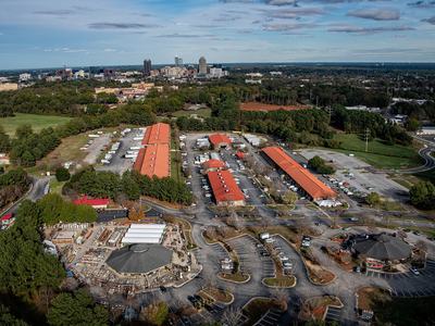 An aerial photo of the state Farmer's Market with downtown Raleigh skyline in the background. Photo by Marc Hall at NC State University.