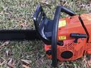Orange chainsaw set on grass