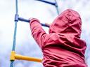 image of child in red coat climbing rope ladder