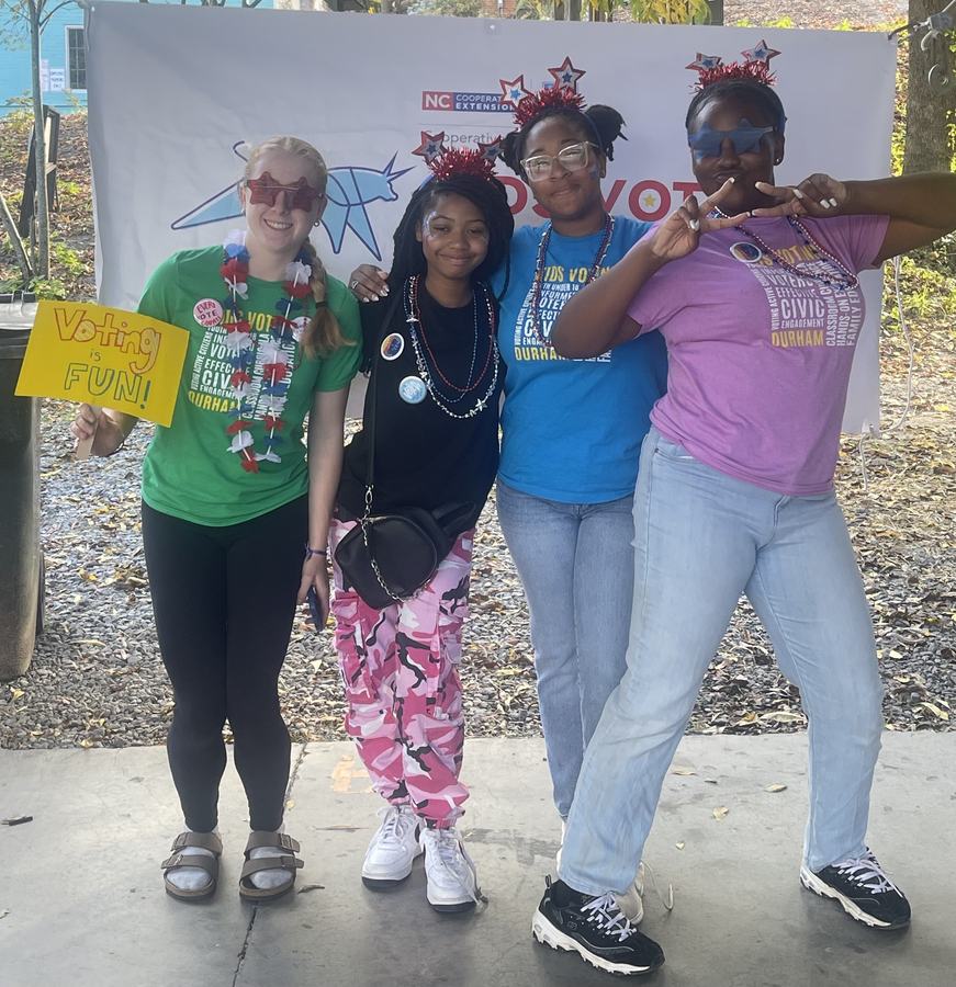 Women pose together with signs supporting voting.