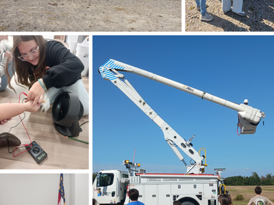 Children and workers standing near a utility bucket truck during outdoor safety demo