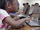 Kids using MacBooks to learn digital skills