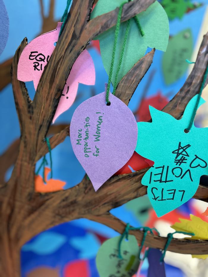 Paper leaves with wishes on a cardboard tree
